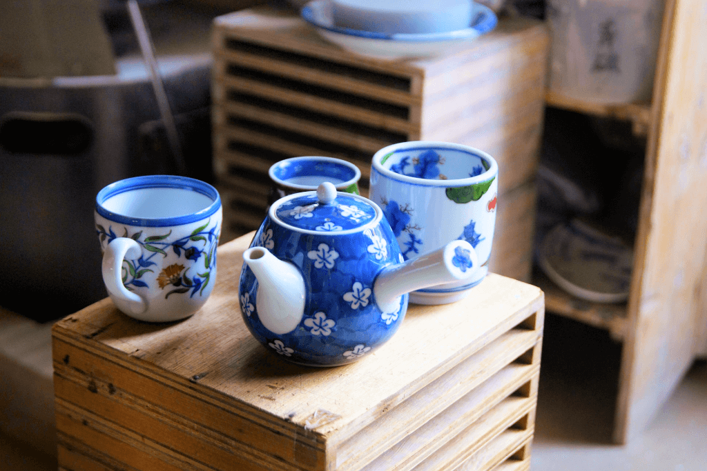 A blue and white Arita tea set on a wooden box. 