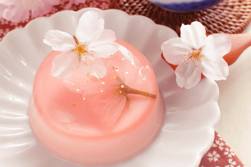 A plate of sakura warabimochi. It's clear pink, with sakura snacks.