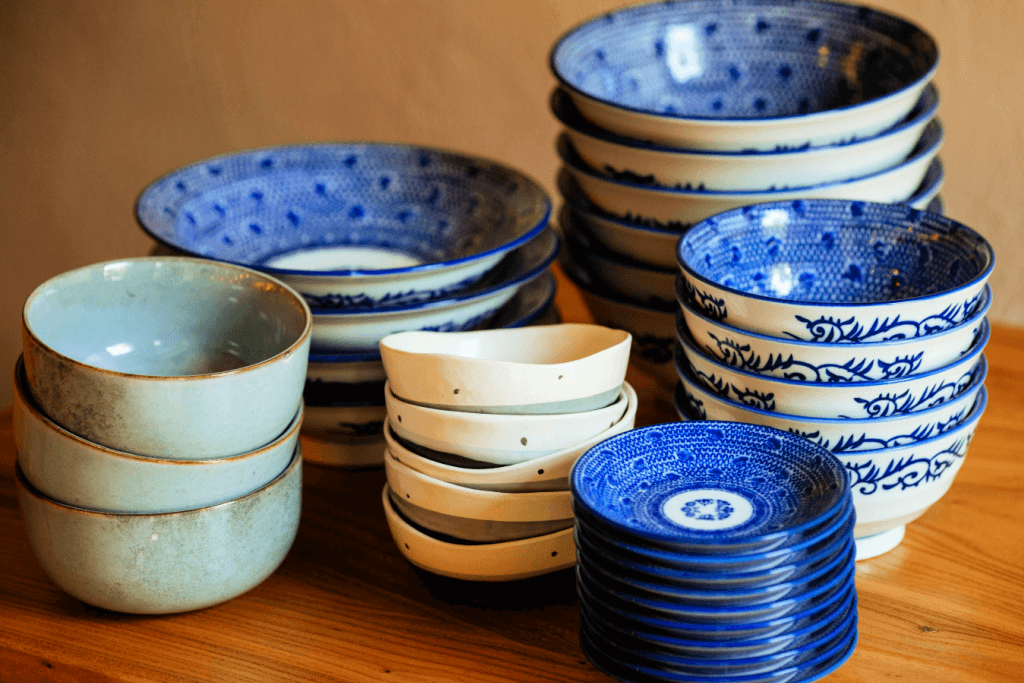 Stacks of Japanese arita tableware on a table. They are blue and white.