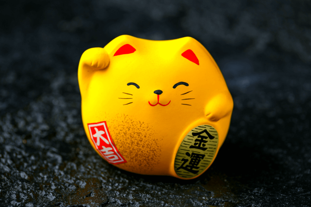 A chubby, yellow cat figurine.