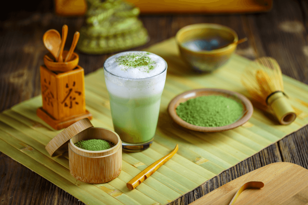 A matcha tea set, including powder, and a latter on a tatami mat with related wooden utensils.
