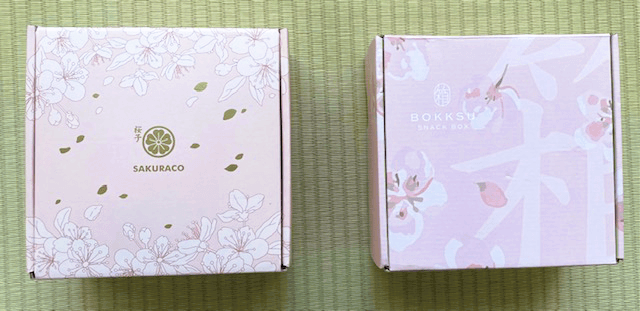 Exterior of Sakuraco and Bokksu's boxes. They are both light pink.