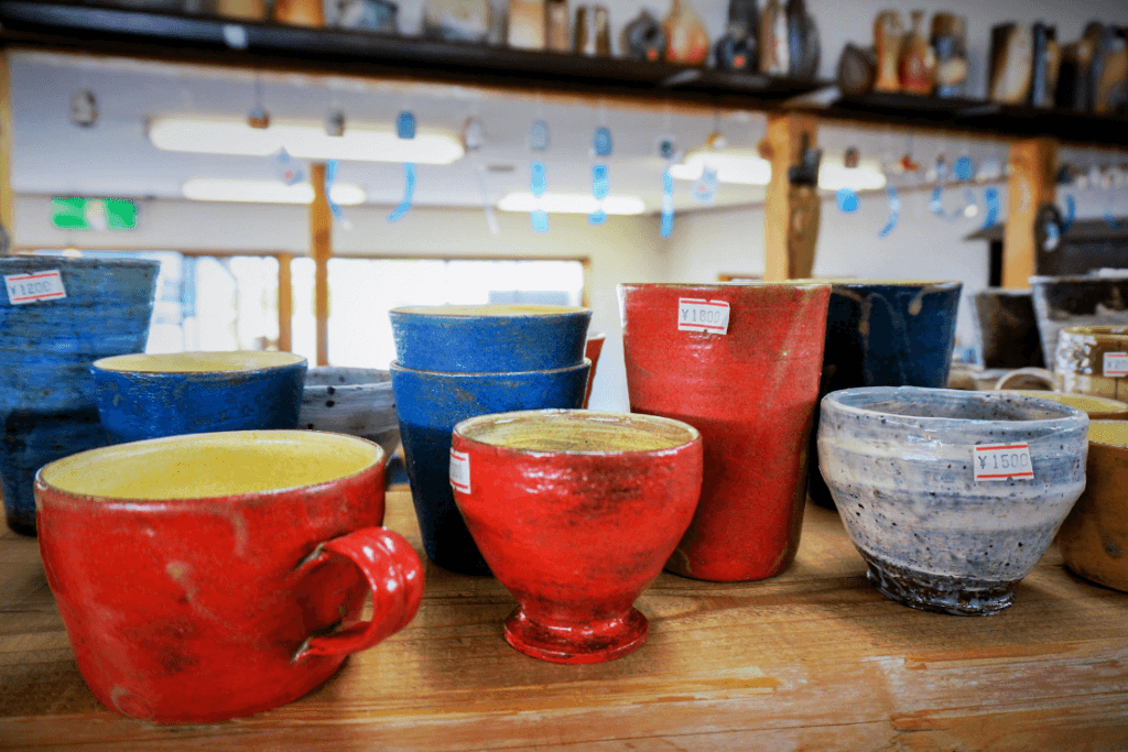 A table full of shigaraki ware, which is red and has a glossy finish. This is one type of the ceramics in Japan.