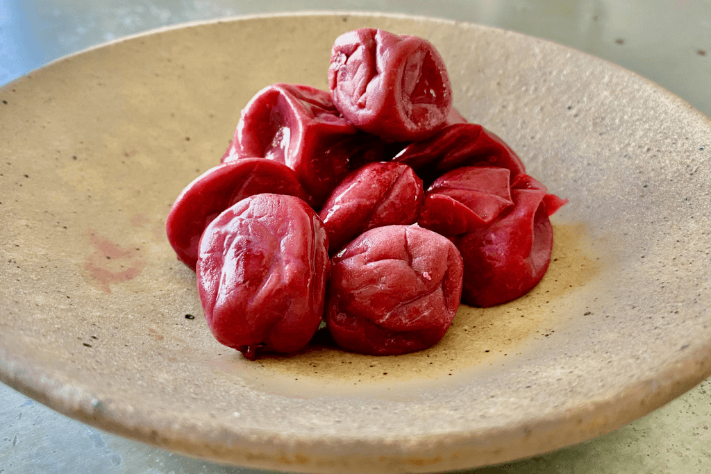 A plate of bright red umeboshi, which uses red shiso for coloring.