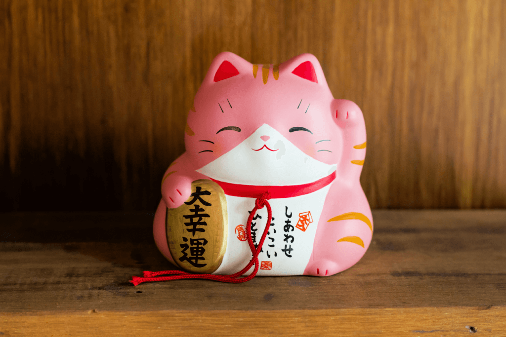 A fat, pink porcelain maneki neko with the left paw raised. It's perfect to include in gift baskets for mom.