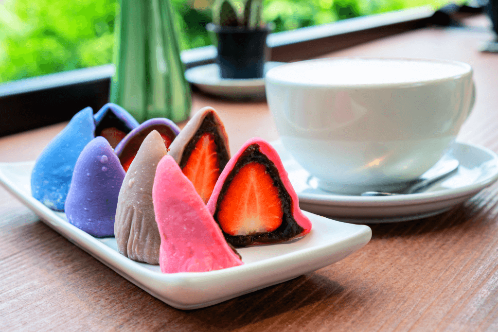 Multicolored ichigo rice cakes of pink, green and purple on a plate.