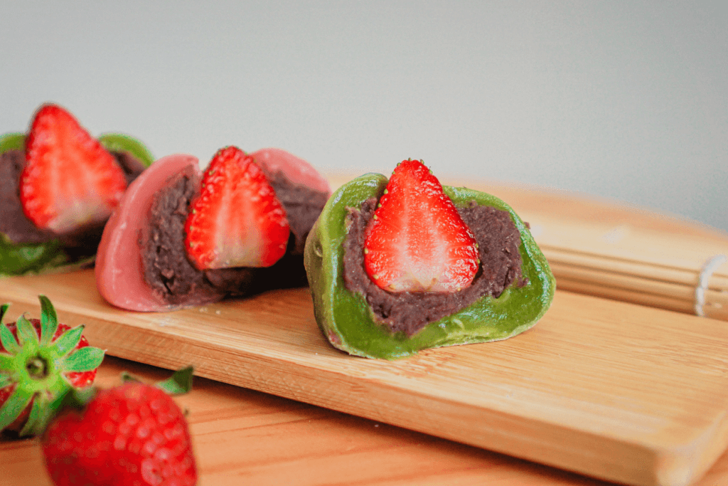 Matcha and strawberry daifuku on a plate.