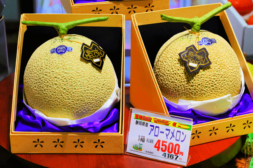 Green melons packaged in a pair of gift boxes.