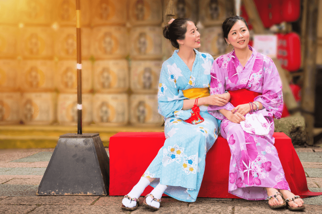 Two women wearing a light blue and hot pink yukata respectively.