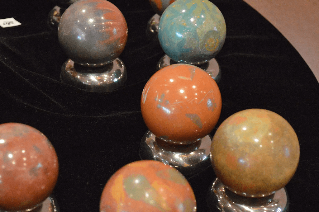 A table full of clay dorodango of various colors.