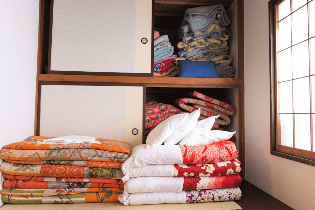 A bunch of parts for a Japanese futon mattress next to a closet.