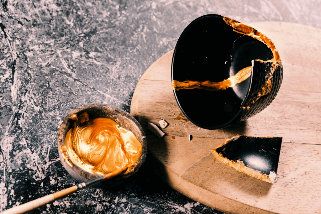 A black bowl next to a bowl of gold lacquer.