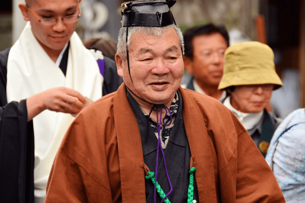 A Shinto priest wearing a brown haori jacket over his kimono.