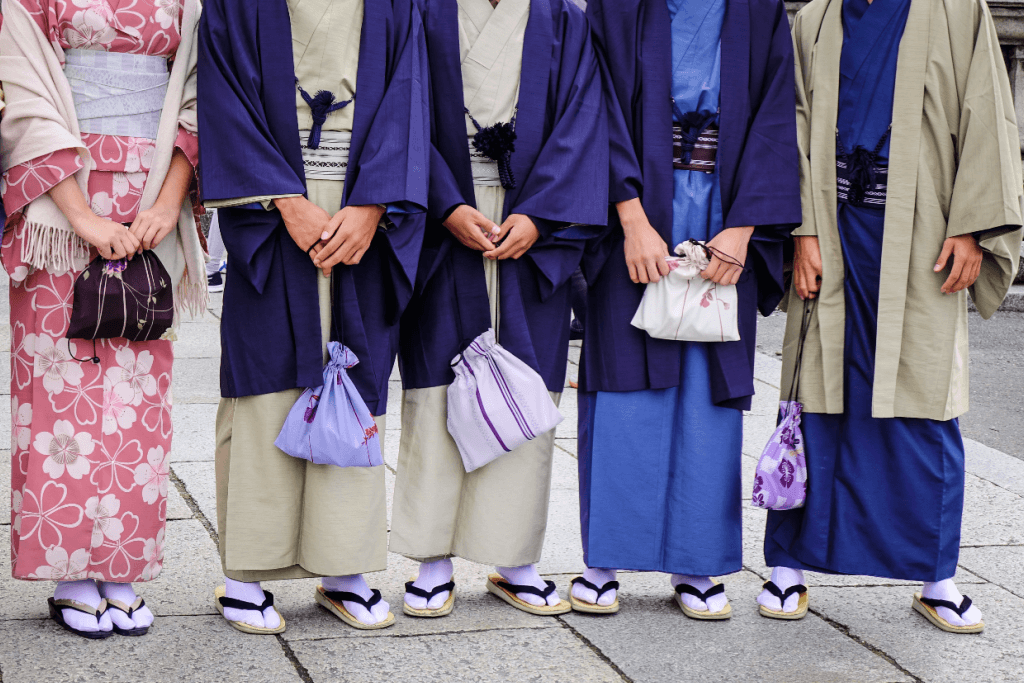 Four men and one woman wearing kimono, blue and pink respectively.