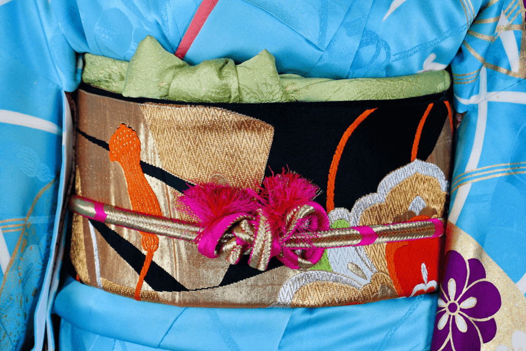 A black and gold kimono sash paired with a blue kimono.