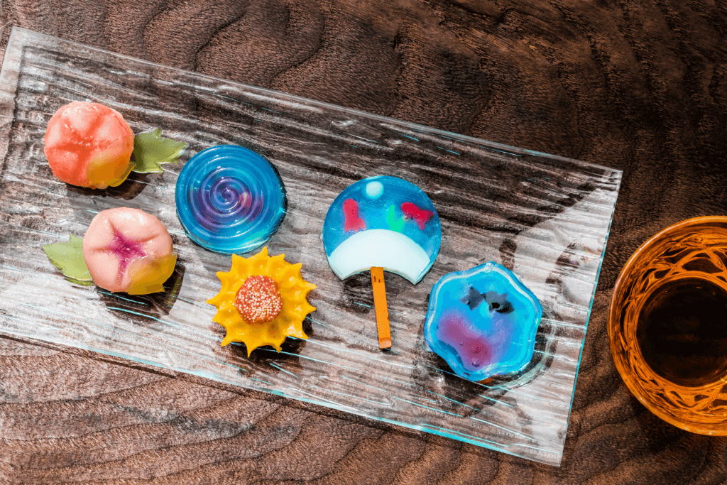 A plate of summer-themed wagashi featuring blue ocean waves and the orange summer sun.