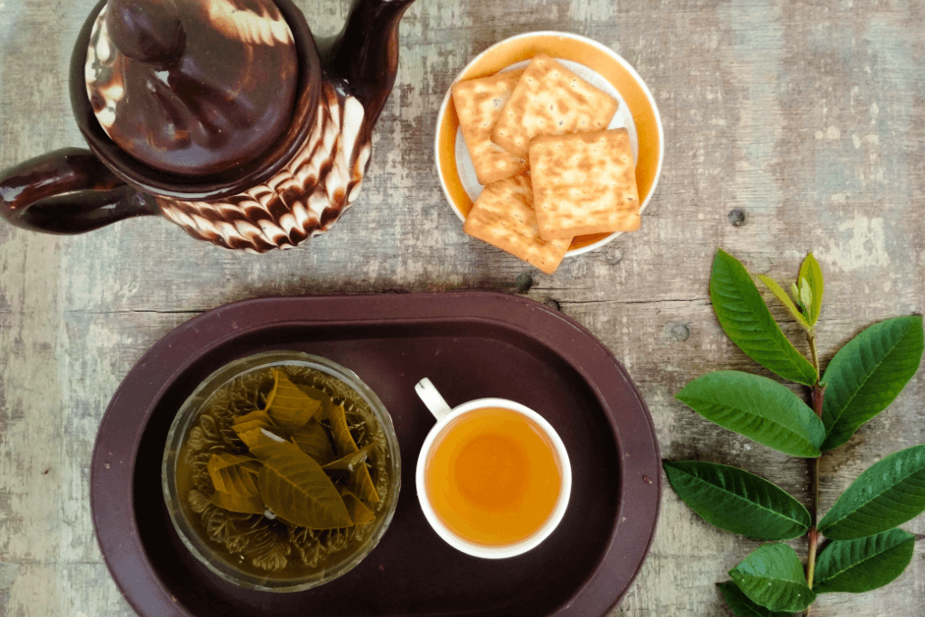 Guava leaf tea with leaves and crackers. It's similar to jasmine tea in appearance.