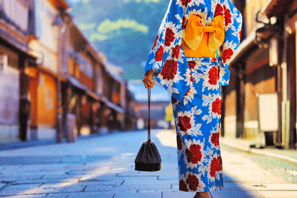 A woman wearing a blue and red yukata (summer kimono) with a bright yellow sash.