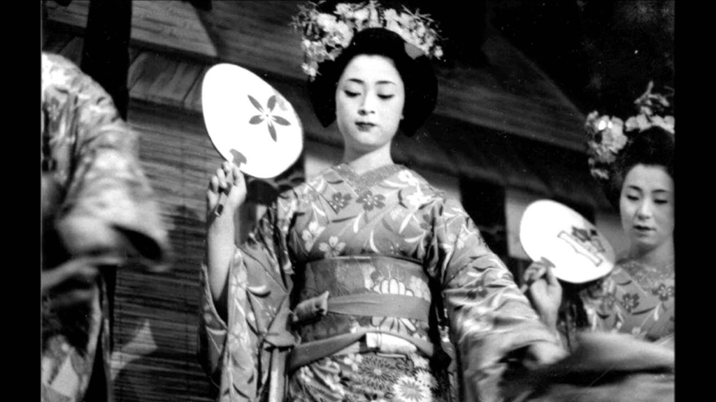 A black and white photo of traditional Japanese performer Mineko Iwasaki.