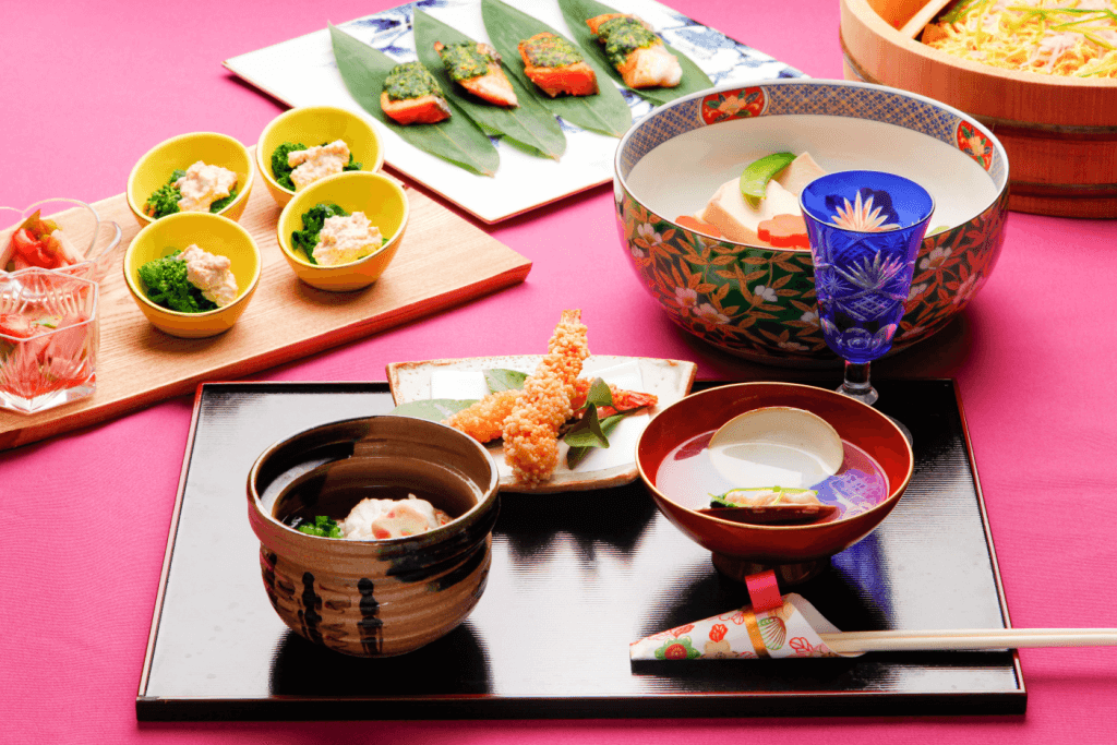 Another multicourse meal with kaiseki dishes against a pink background.