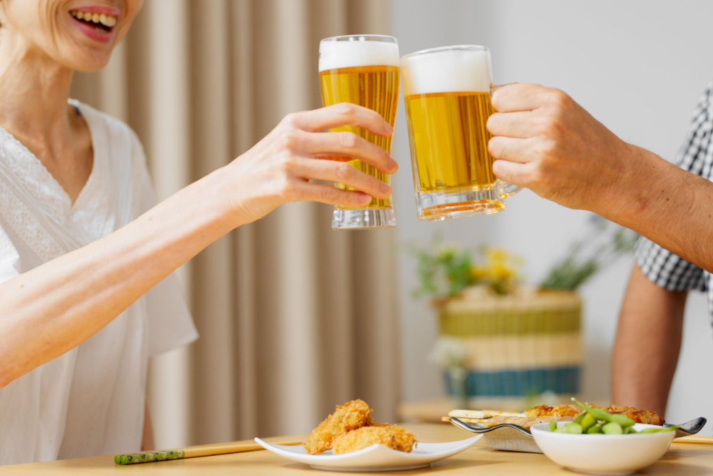 People toast with beer while enjoying Japanese snacks