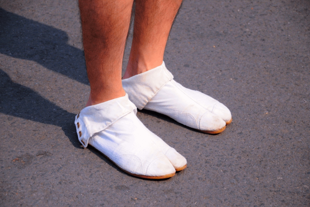 A person wearing a pair of white jika tabi.