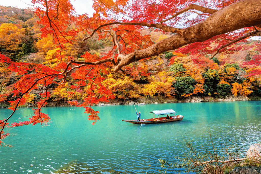 A boat on a clear blue lake among momiji in Tokyo.