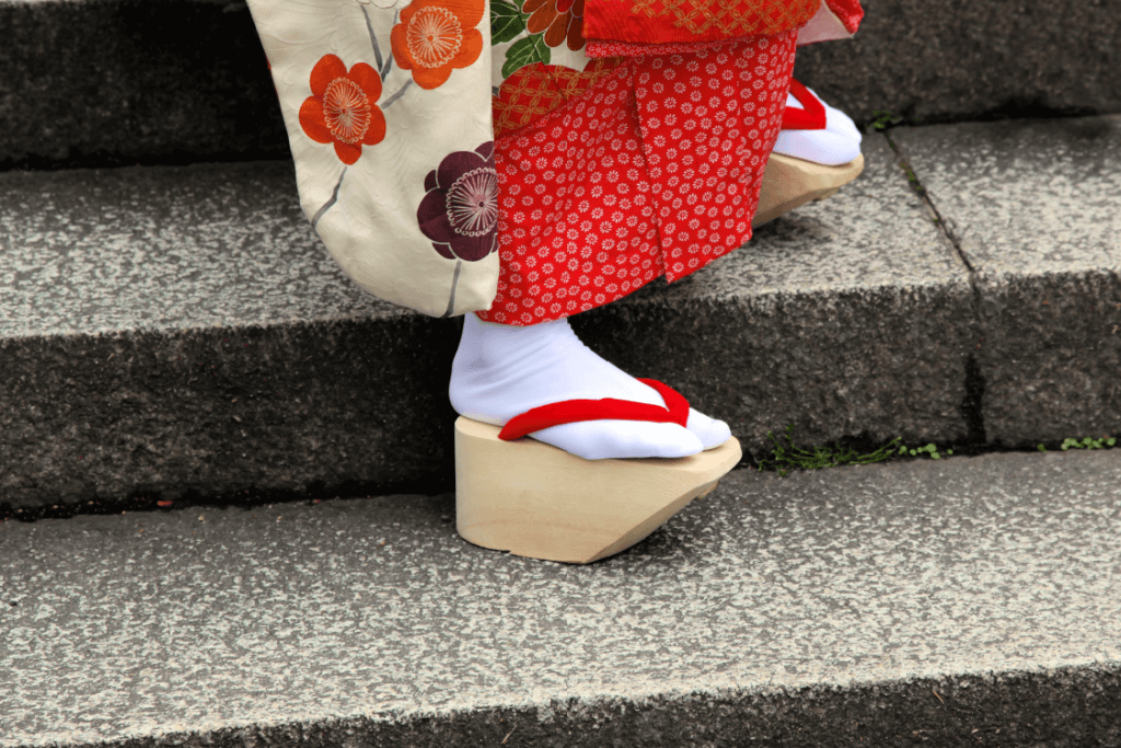 A geisha wearing tall okobo sandals.