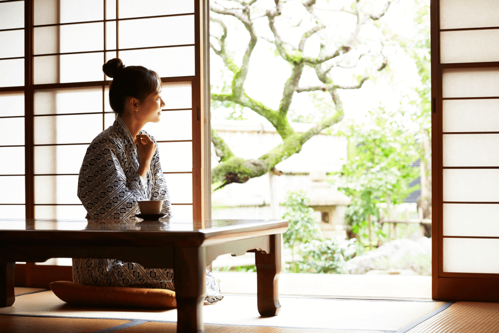 A woman relaxing at a table in a ryokan.