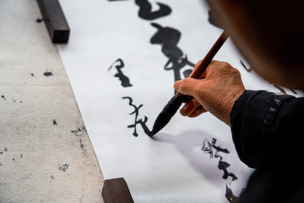 A person doing Japanese calligraphy in semi-cursive script.