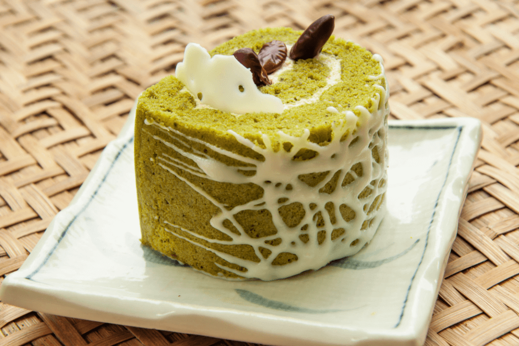 A matcha Swiss roll with white icing.