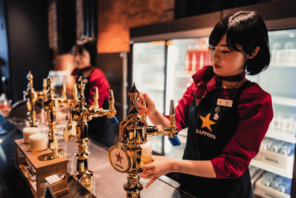 People pouring beer at the Sapporo Beer Museum.