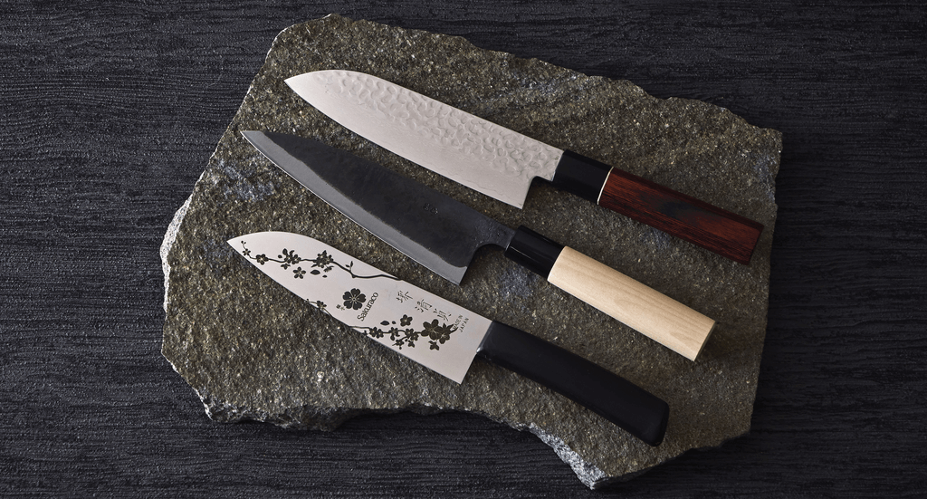 Three unique Japanese knives from Sakuraco on a grey stone slab.