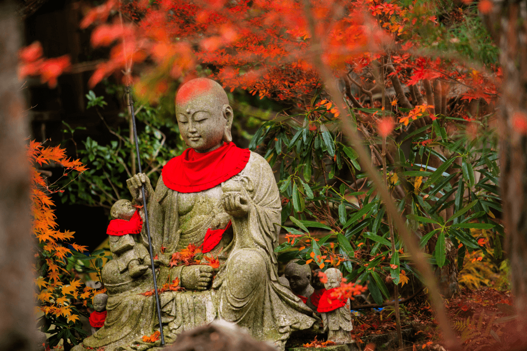 A Jizo statue with a red bandanna around its neck.