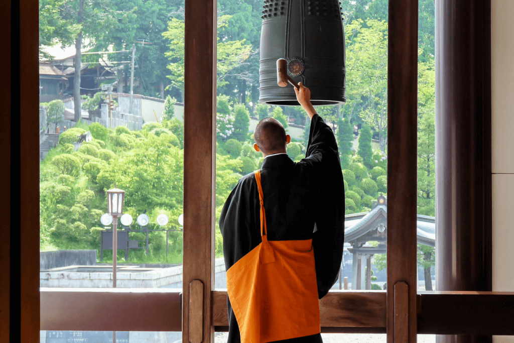 A monk ringing a bell at a Buddhist monastery.