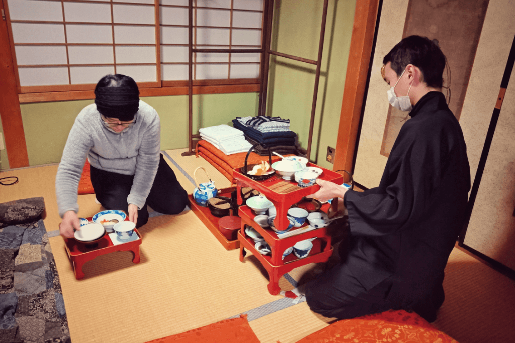Two people serving food at a Buddhist monastery.