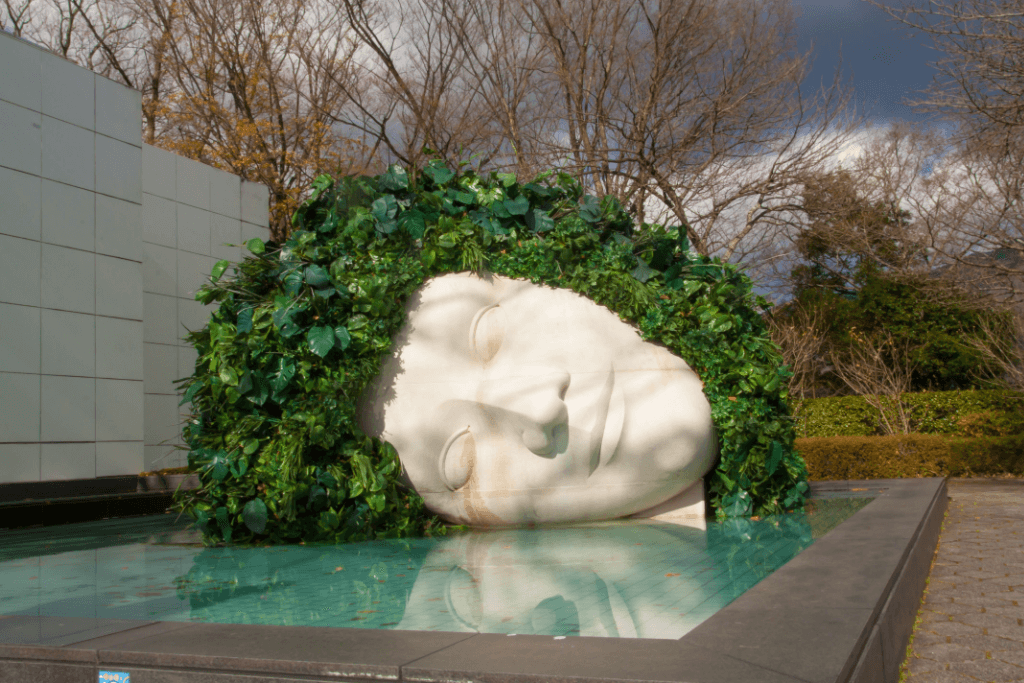 A vine covered marble statue head at the Hakone Open-Air Museum.