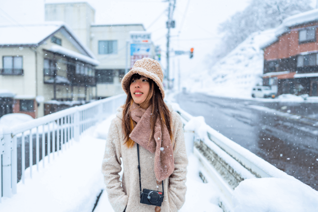 A woman enjoying the wintry weather in Japan while walking down the street.