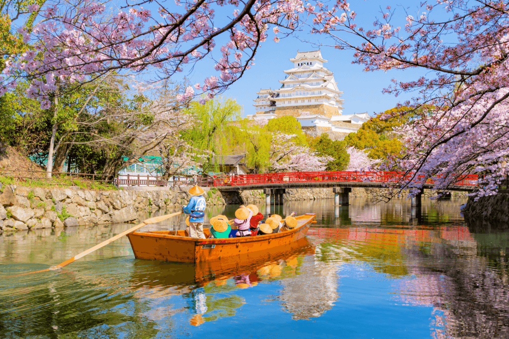 People riding on a boat near the Himeji Castle moat.