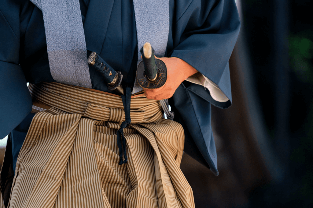 A swordsman wearing kenpozome hakama and a blue top.
