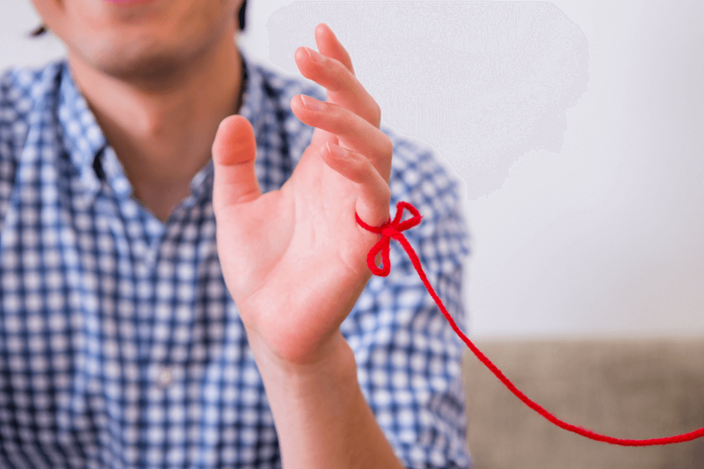 A pinky connected by the red thread of fate.