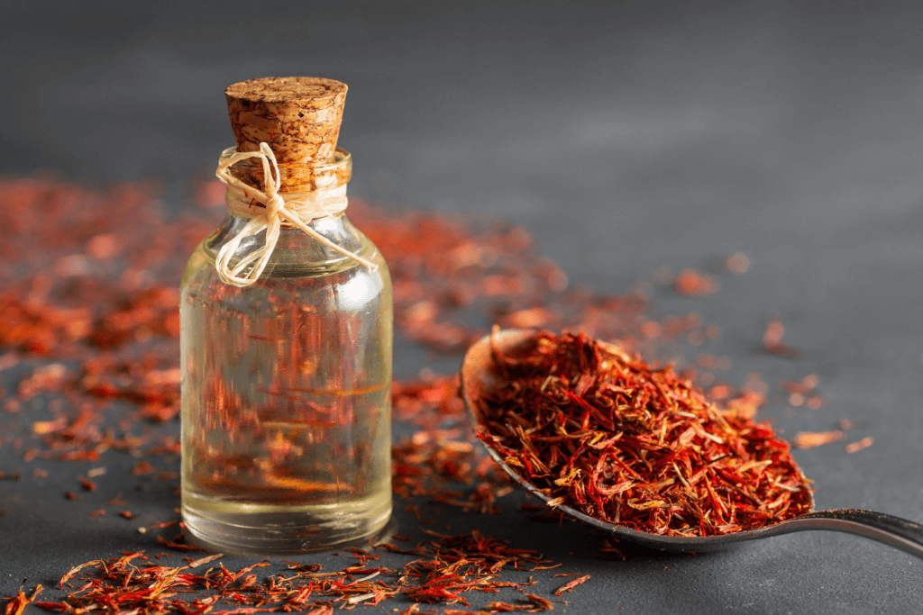Red safflower petals and a spoon with safflower oil.