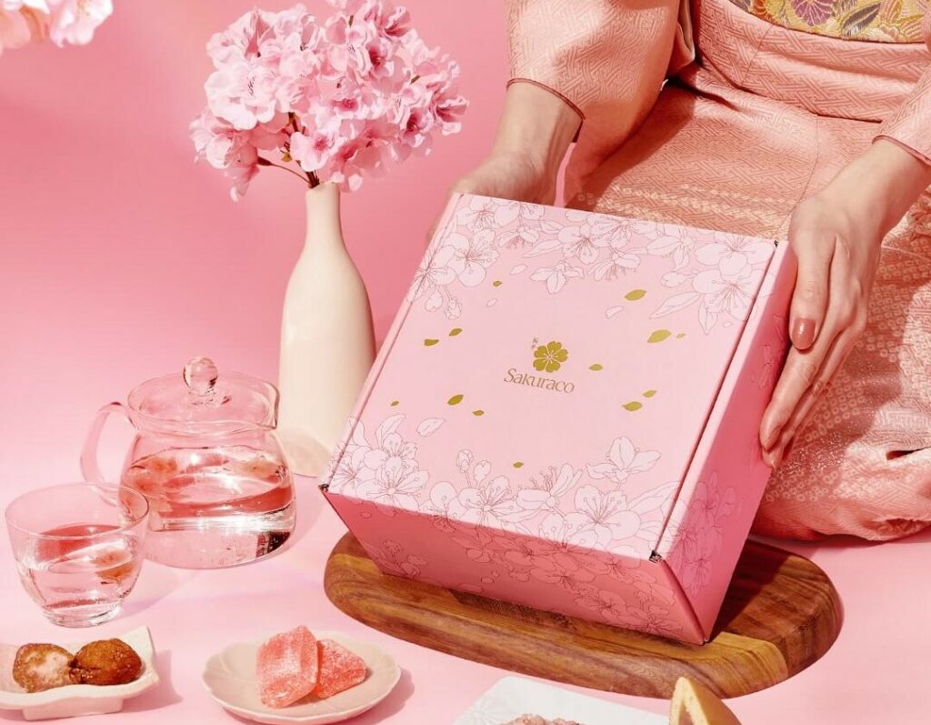 A woman holding a cherry blossom snack box from Sakuraco for International Women's Day