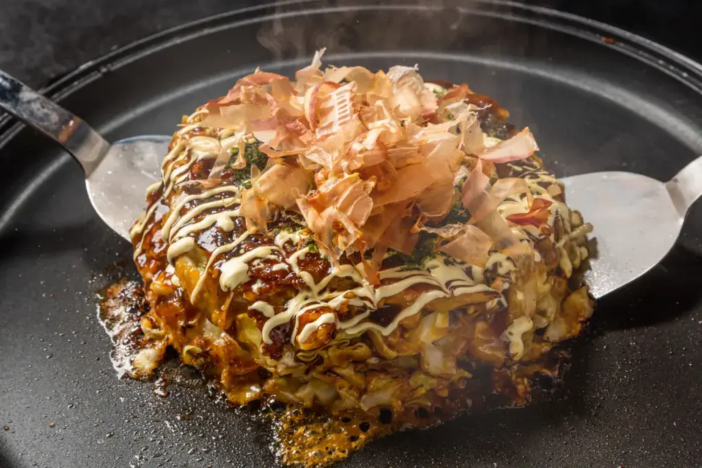 Okonomiyaki on a griddle.