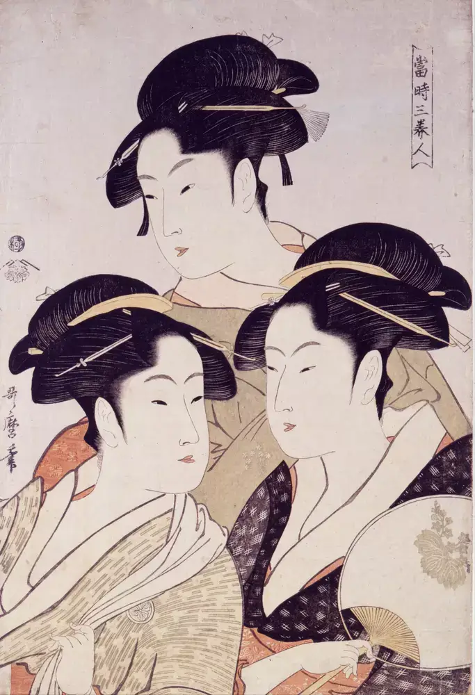Three women (two on bottom, one top) with their hair done up.