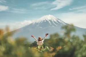 A woman facing Mt., Fuji with her arms raised, perhaps during Golden Week 2019.