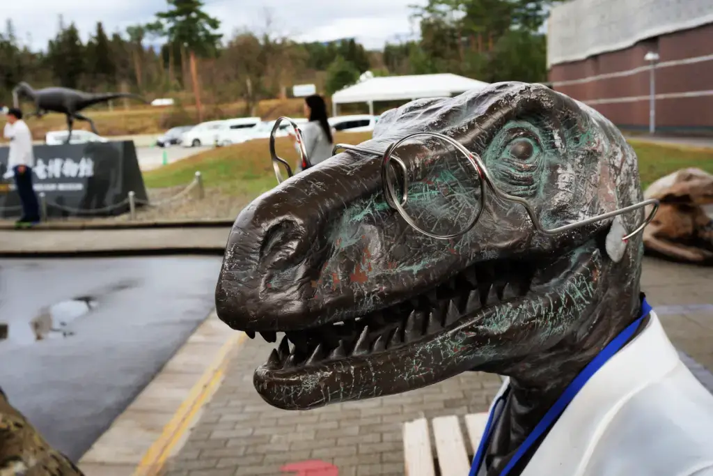 A T-rex statue with glasses and a lab coat.