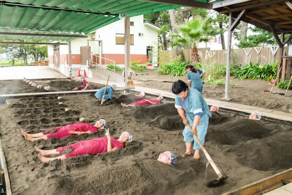 People burying customers in hot sand for a spa treatments.