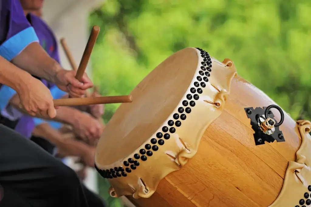 Someone playing a large taiko drum, one of many traditional Japanese instruments.