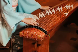 Someone playing a koto, one of many traditional Japanese instruments.